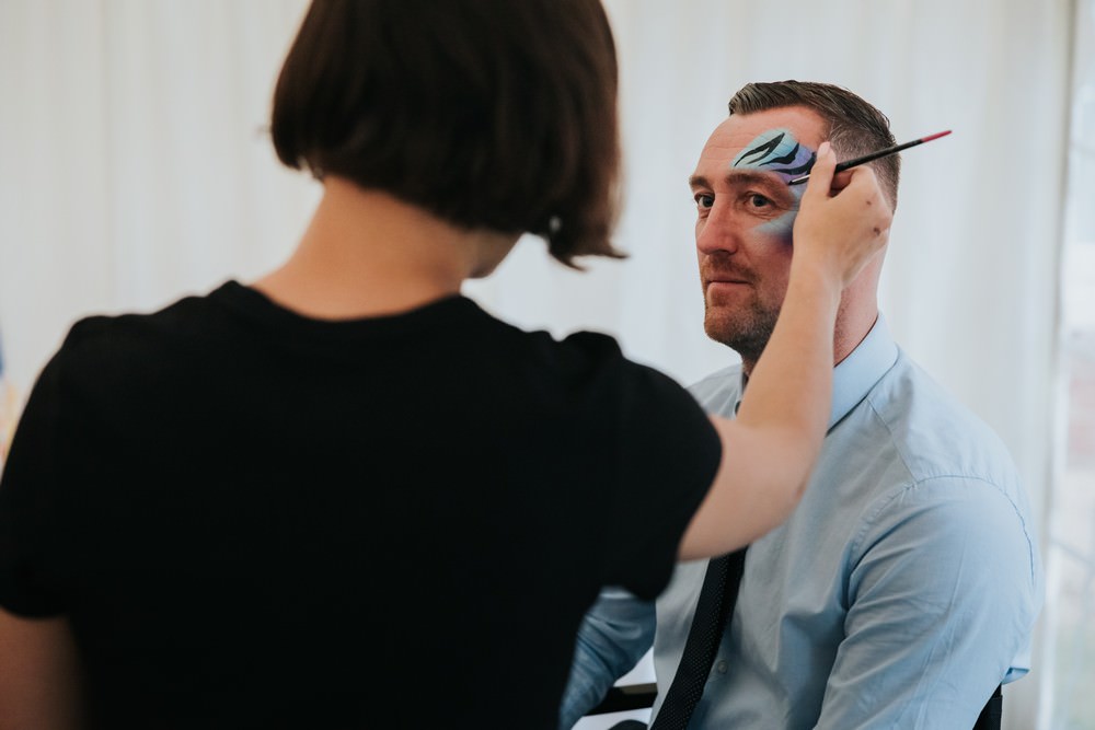 adult wedding guest getting face painted