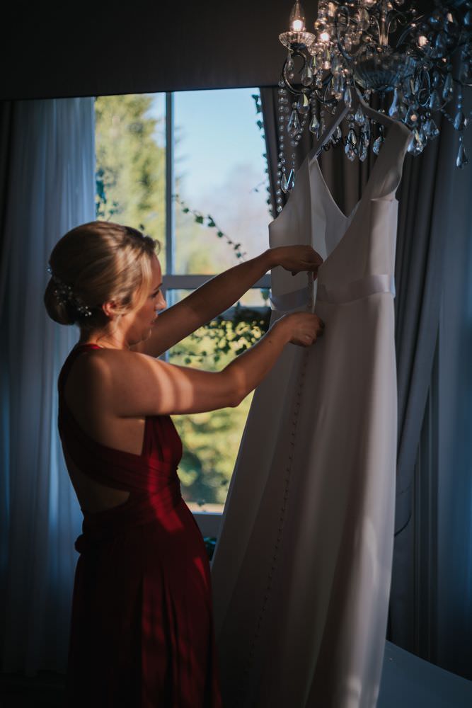Bridesmaid hangs up dress at Bartle Hall wedding.