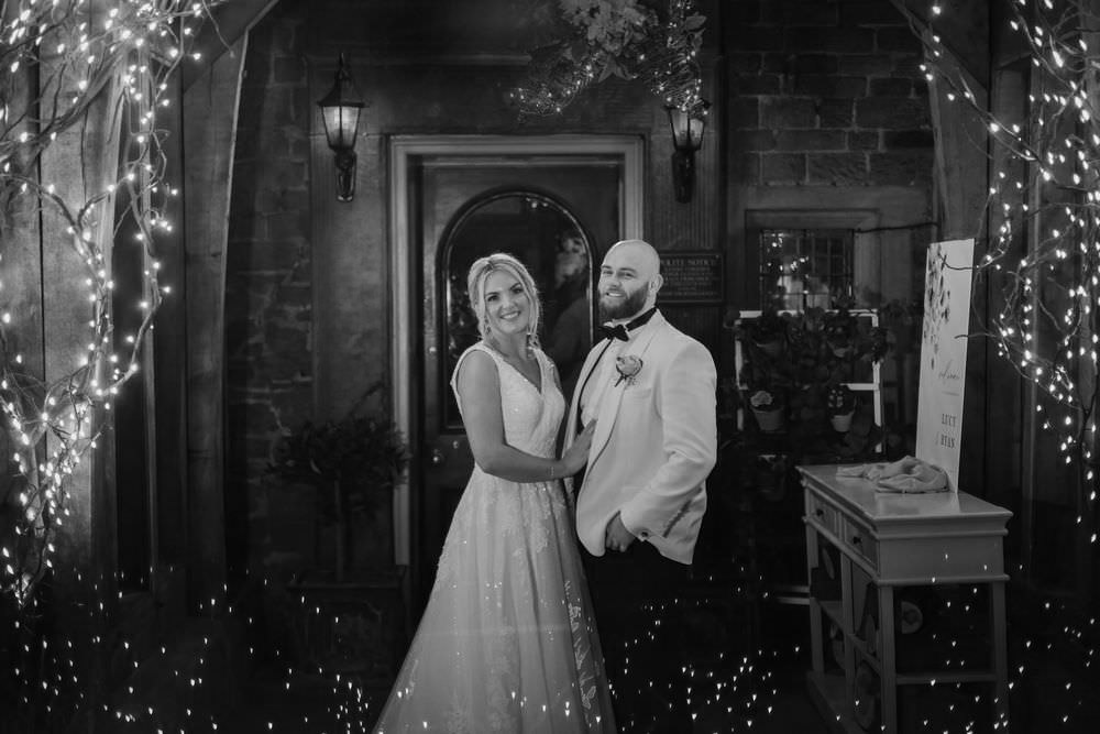 bride and groom in front of whitley hall entrance at nighttime