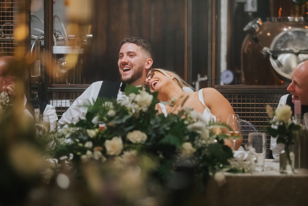 bride and groom laughing at top table