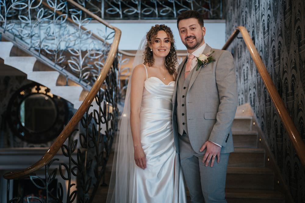 bride and groom on stairs at grosvenor pullford chester wedding