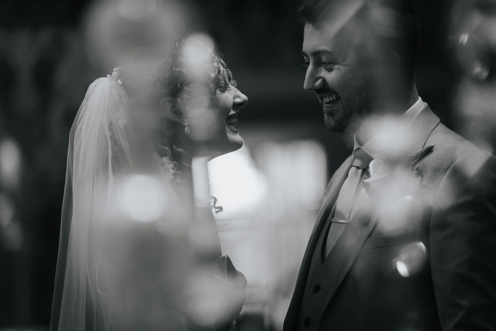bride and groom smiling framed by chandelier at grosvenor pullford chester wedding
