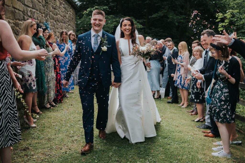 bride and groom walking through confetti at pendle heritage centre