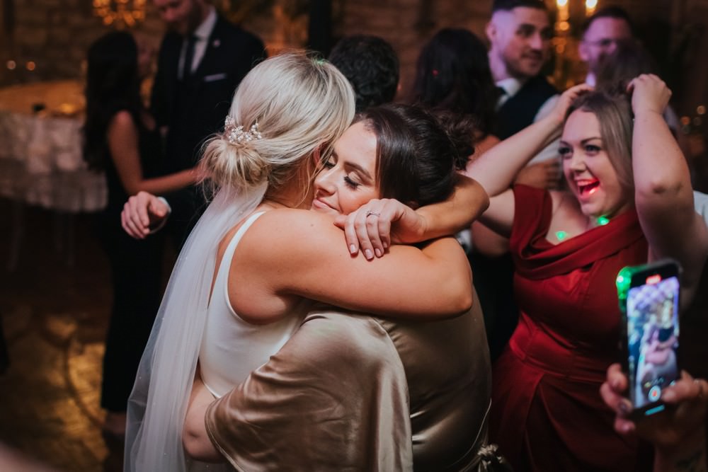 bride hugs guest on dancefloor