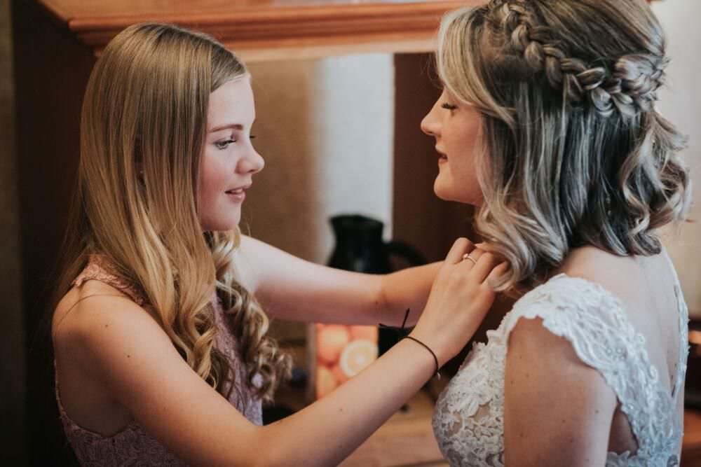flower girl puts necklace on bride at parsonage york