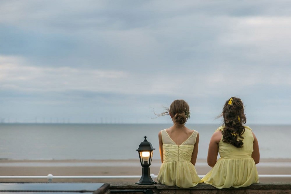 flower girls staring out to sea