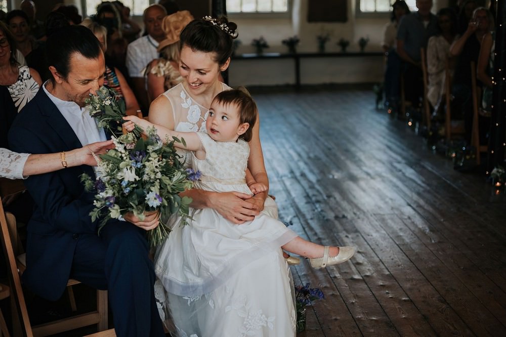 gibson mill wedding child shoves flowers into grooms face