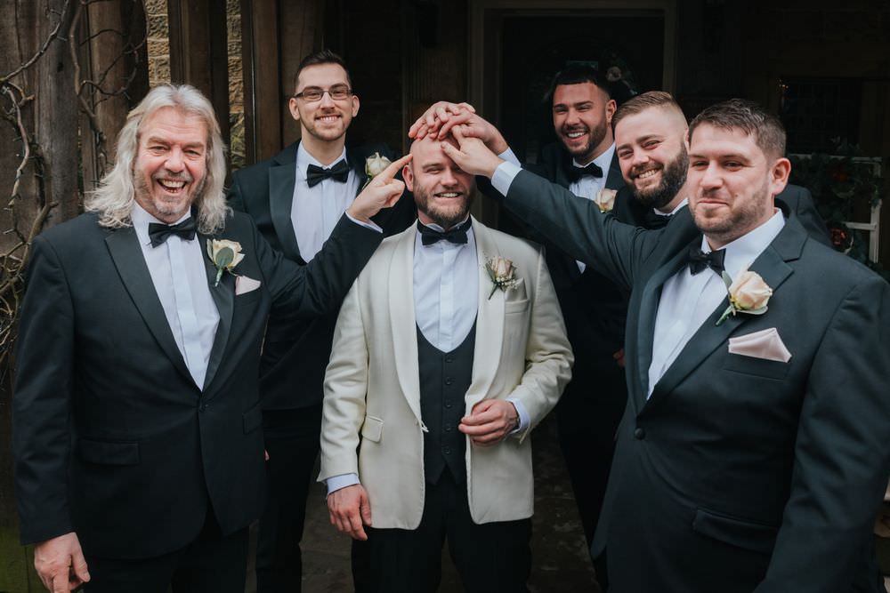 groomsmen rubbing grooms head at groom laughing at whitley hall sheffield wedding