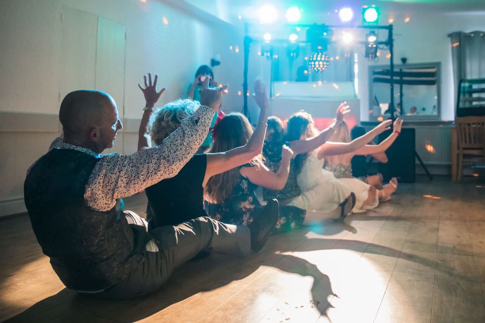 guests wave arms on dancefloor at windy harbour wedding