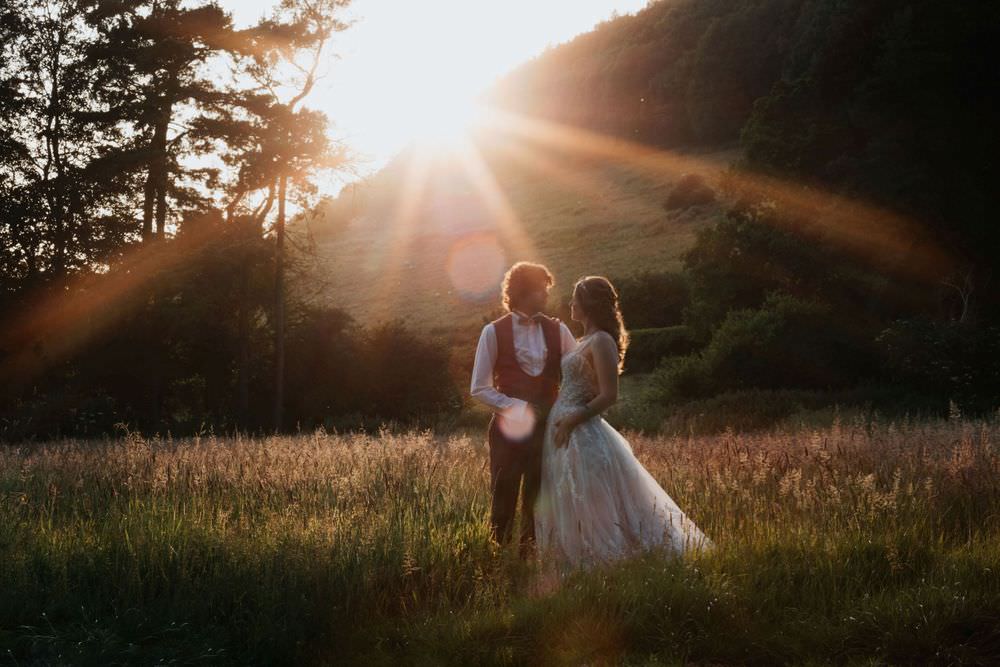 bride and groom with sunset behind at hackness grange