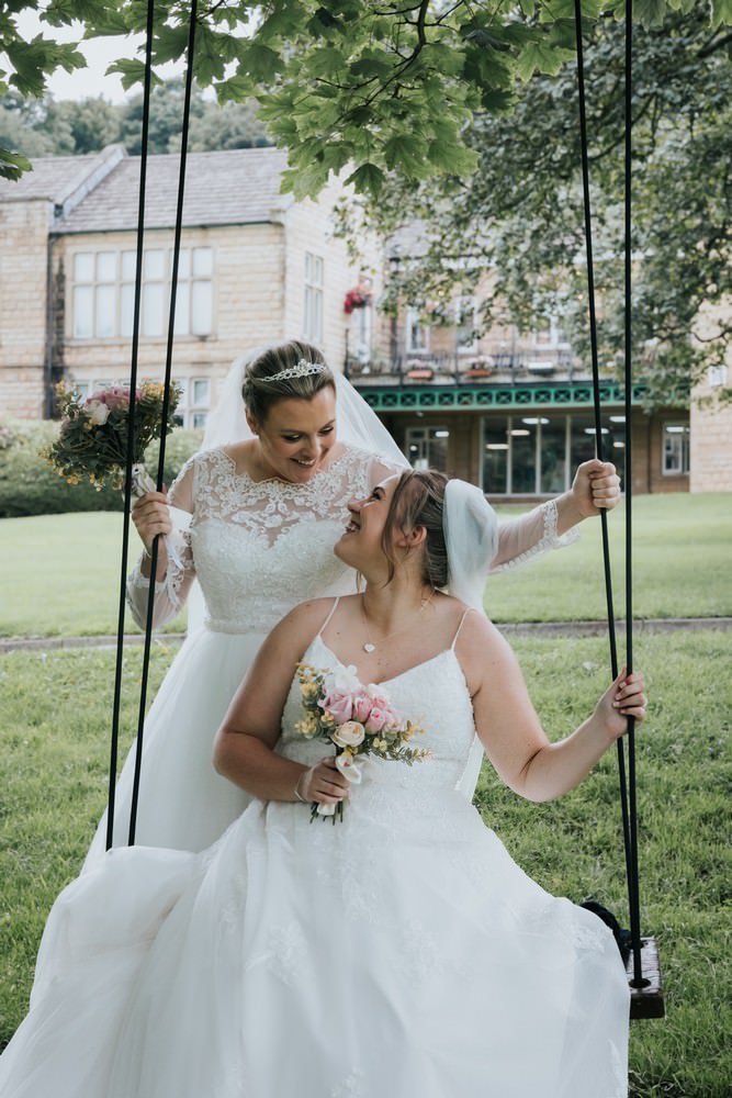 hollins hall wedding two brides smiling on a swing
