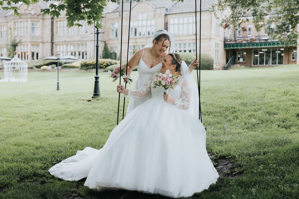 two brides on swing at hollins hall wedding