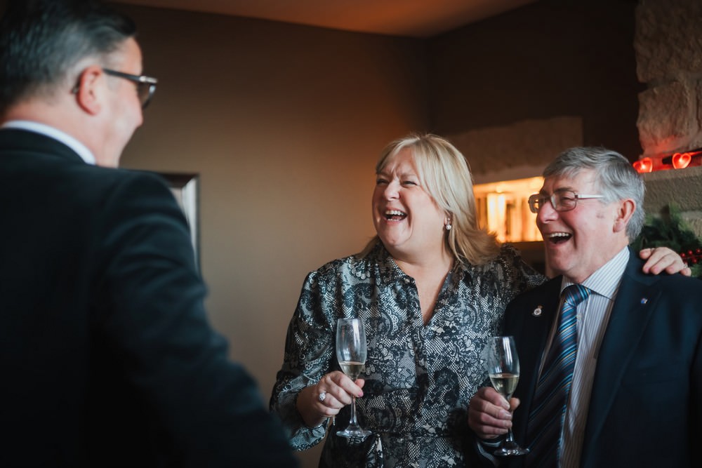 wedding guests laughing holding wine